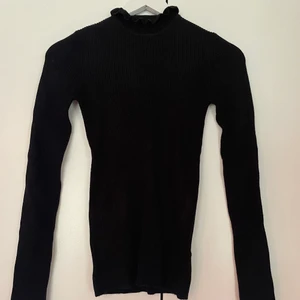 Tröja - Svart tröja med halvpolo från Gina, väldigt stretchigt material som är ribbat