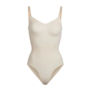Skims sculpting bodysuit- sand - Säljer denna populära bodysuiten från skims i nyskick! Jätte snygg men tyvärr för liten för mig. Nypris 685kr, men köptes för över 800kr (då frakten kostar mycket)