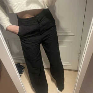 Kostymbyxor - Säljer ett par jättefina högmidjade/mid waist (osäker) kostymbyxor med slits nedan vid anklarna på båda benen ifrån H&M, i storlek 34, köpta för 400 och säljer för 200.