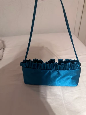 Mini väska grön/blå - En mini väska från asos, helt oanvänd. Hör av dig om du är intresserad!😊
