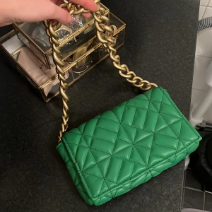 GRÖN VÄSKA ZARA - Säljer denna snygga gröna festväskan med guld kedja. Väskan är aldrig använd i nyskick. Säljer för 180 Kr! Köparen står för frakten! 