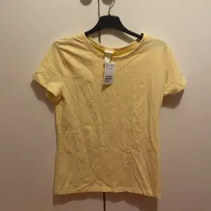 En supersöt gul t-shirt från H&M. Nyskick och aldrig använd då mamma köpte fel färg åt mig :( . Kan enkelt strykas! Originalpris: 50 kr