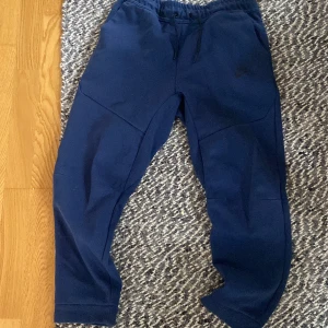 Nike tech byxor (blå)  - köptes från USA för 999kr, säljer nu för att det aldrig blev till användning. Start bud 400. De finns inga defekter. Helt som nya. Det är barn storlek i storlek L Köparen står för frakten som kostar 69 kr. 