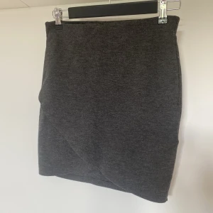 Grå kort kjol - Säljer en grå kort kjol med liten slits. Storlek small. Resår i midjan. Från Gina Tricot 