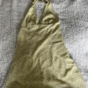 Sommarklänning - Gullig sommarklänning med halterneck från H&M, använd en gång. Storlek Xs!