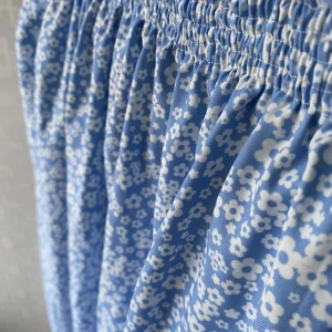 Blommig kjol - En blå blommig kjol som är sydd själv. Den har en resår i midjan som gör att kjolen sitter jättefint😻materialet är lite glansigt och är jättefin till sommaren💞säljer för 75kr. Jag är 175 lång och brukar ha M/L på kjolar☺️