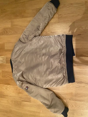 Bomber jacka  - Säljer en bomberjacka som är vändbar. Ena sidan är mörkblå och andra är guld. Är i gott använt skick 