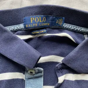 Säljer nu min Ralph Lauren piké i storlek S. Den är i använt skick, har endast några små hål under armen (se bild 3). Nypris på denna är 899kr, säljer för 150kr.  Tveka inte att höra av dig vid funderingar!