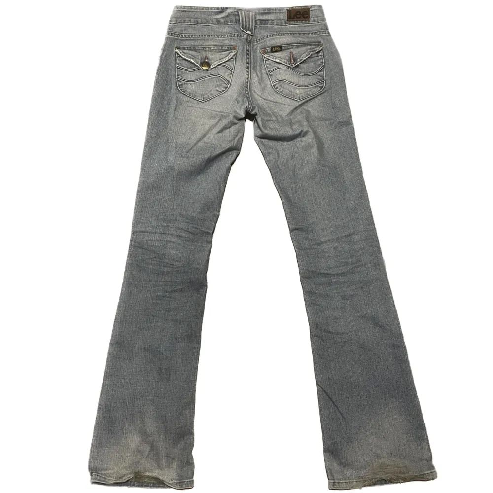 Ett par trendiga lågmidjade Lee jeans i strl W27 L35 med coola fram, och bakfickor. Välanvända och en av knapparna har ramlat av (se sista bilden). Sitter väldigt snyggt på. Midjemått tvärs över: 37cm längd: 107 cm innebenslängd: 86cm ✨möts i Stockholm✨. Jeans & Byxor.