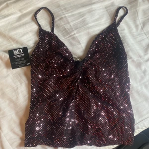 Glittrig topp - En fin glittrig fest topp i strl M från Nelly. Aldrig använd med lappen kvar. Säljer för 70kr 
