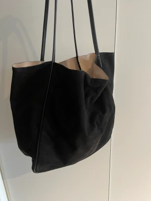 Väska  - En större svart väska som får plats med massor i sig 