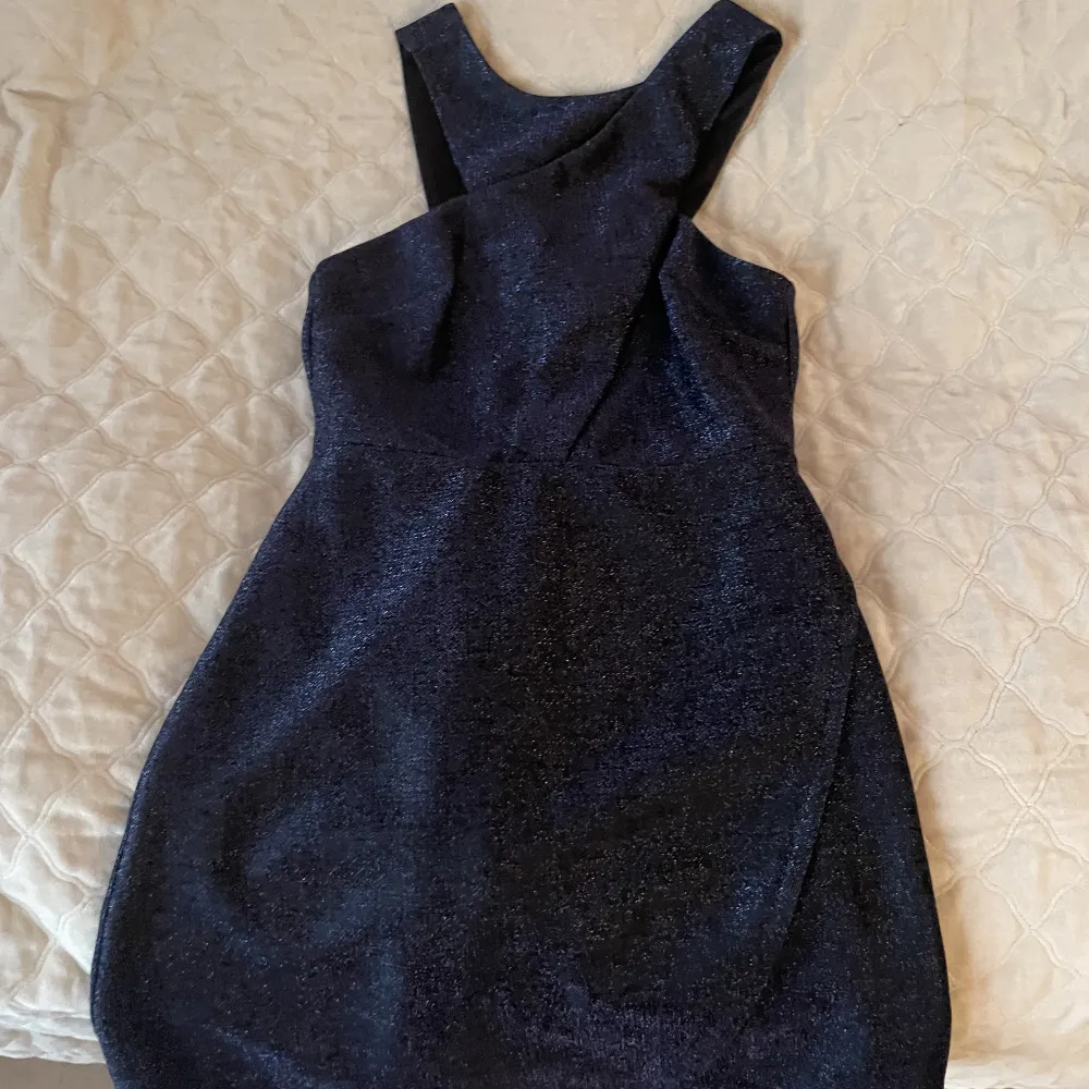 Glittrig klänning med lappen kvar, aldrig använd. Mörkblå glittrigt material. Klänningar.