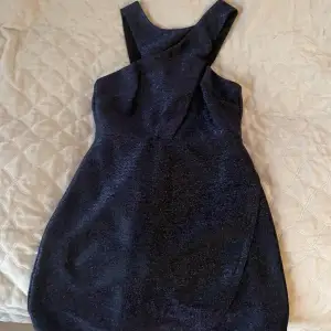 Glittrig klänning med lappen kvar, aldrig använd. Mörkblå glittrigt material