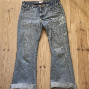 Jeans med broderade blommor - Jättefina blåa jeans med broderade blommor! Knappt använda och i mycketbra skick.