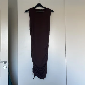 Tight Ribbad klänning - Ribbad figurnära klänning med rysch i sidorna (ej justerbara), går till strax nedanför knäna. Stl 44 men sitte romer som en 40, provad men aldrig använd.