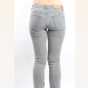 Acne jeans - Snygga gråa Acne jeans med slit där nere så de är lite mer åt bootcut hållet.   Midjemått: 79 cm  Längd: 100 cm  Innerbenslängd: 75 cm För mer bilder  hur de ser ut på, kontakta oss🤗 JUST NU 100 KR RABBAT PÅ ORDENARIE PRIS 300 kr! Passa på! 