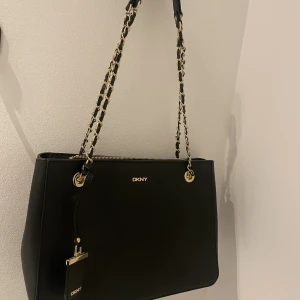 Handväska DKNY - Väska från DKNY med dragkedja och tre innerfack. Får plats en liten dator eller iPad, bredd 33 cm, djup 12 cm och höjd 13 cm. 