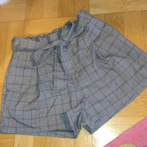 Shorts med band - Aldrig använda Typ chinos tyg med resor vid ryggen bältet är inbyggt kan knytas bak eller fram Korta men täcker rumpan 