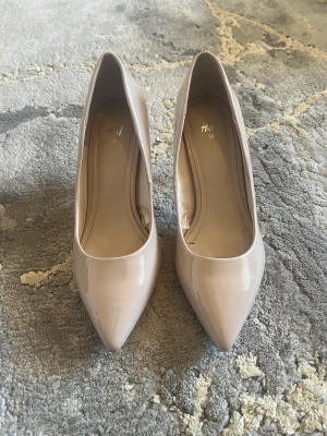 Klackskor - Oanvända klackskor i strl 36 Färgen är beige/rosa 