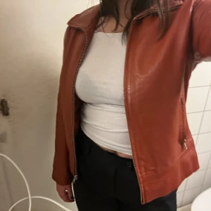 VINTAGE LÄDERJACKA - Supersnygg vintage rostbrun/orange-röd jacka säljes. Äkta läder. Fint skick. Strl: 38. 