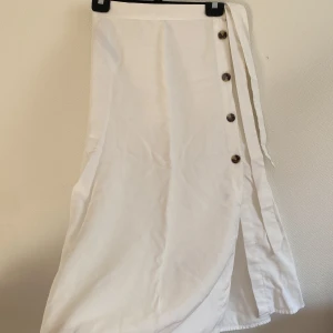 Midilång kjol perfekt skick - Så söt kjol som tyvärr inte kommer till användning! Knyte & knappar vid sidan. Supermjukt och flowy material.