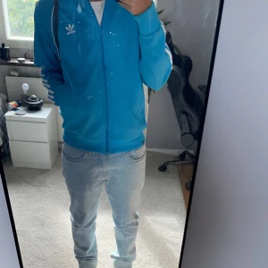 Adidas sweatshirt - En ljusblå adidas zip sweatshirt köpt på Jd för runt 900 kr är inte använd så mycket och är helt skadefri. 