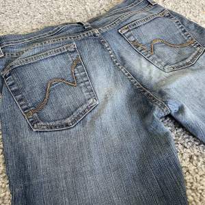 Säljer dessa lågmidjade jeansen med snygga fickor. Midjemått: 38 cm tvärs över, Iinnebenslängd: 80cm💕Liten skråma på vänstra bakbenen annars perfekt skick