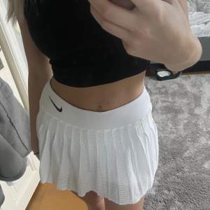 En vit tenniskjol från Nike med tighta shorts under. På tredje bilden kan man se att lite av nikemärket har gått bort annars är den i mycket fint skick! 