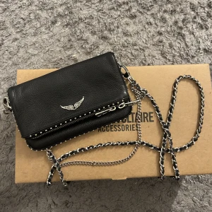 Zadig Väska - Säljer min Zadig väska. Använd en del och kedjan har blivit lite missfärgad men annars inga defekter och i fint skick 💕😋 skriv för fler bilder 