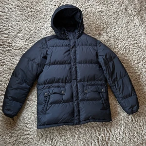 Prada dunjacka - Prada dunjacka , sparsamt använd där av försäljningen.  Färgen är mörk, mörk blå. Storlek 52, L, jag är 175 cm medelbyggd. Jackan är inköpt i en prada butik i Madrid av min mor för ett år sedan.  Jag står för frakt eller möte i Gbg