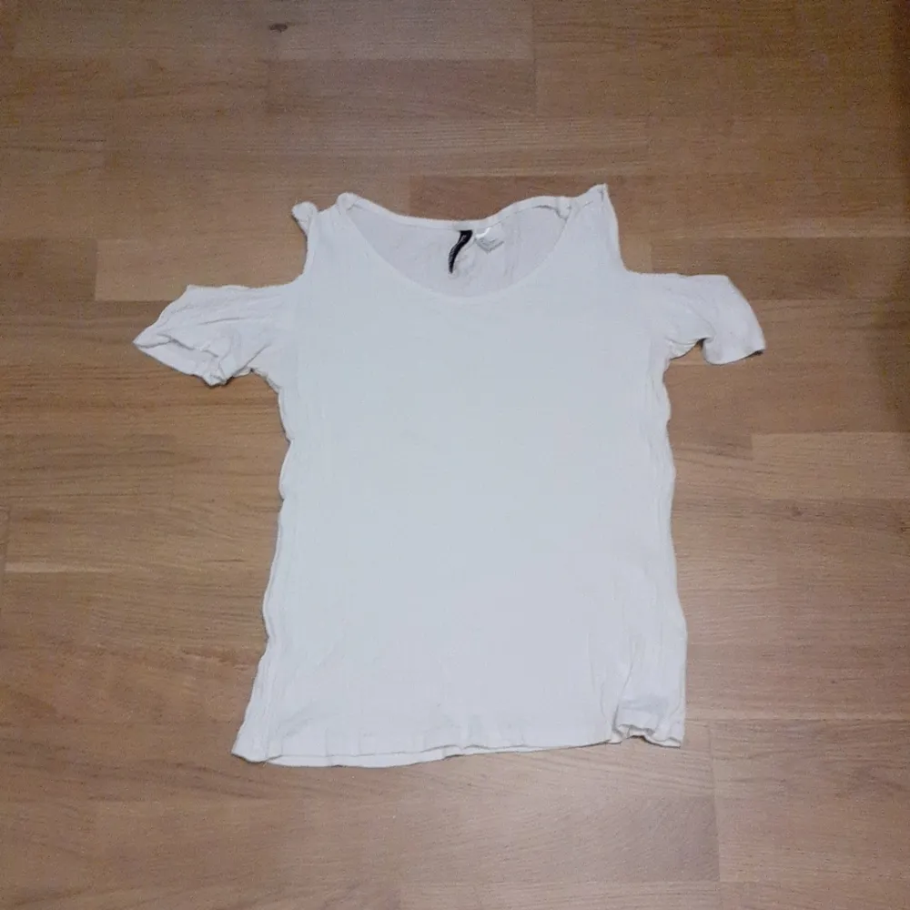 En fin vit t-shirt med ihåliga axlar som passar in i sommarn som kommer om ett tag. Har ingen användning av den så därför säljer jag :). T-paidat.