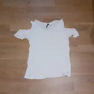 En fin vit t-shirt med ihåliga axlar som passar in i sommarn som kommer om ett tag. Har ingen användning av den så därför säljer jag :)