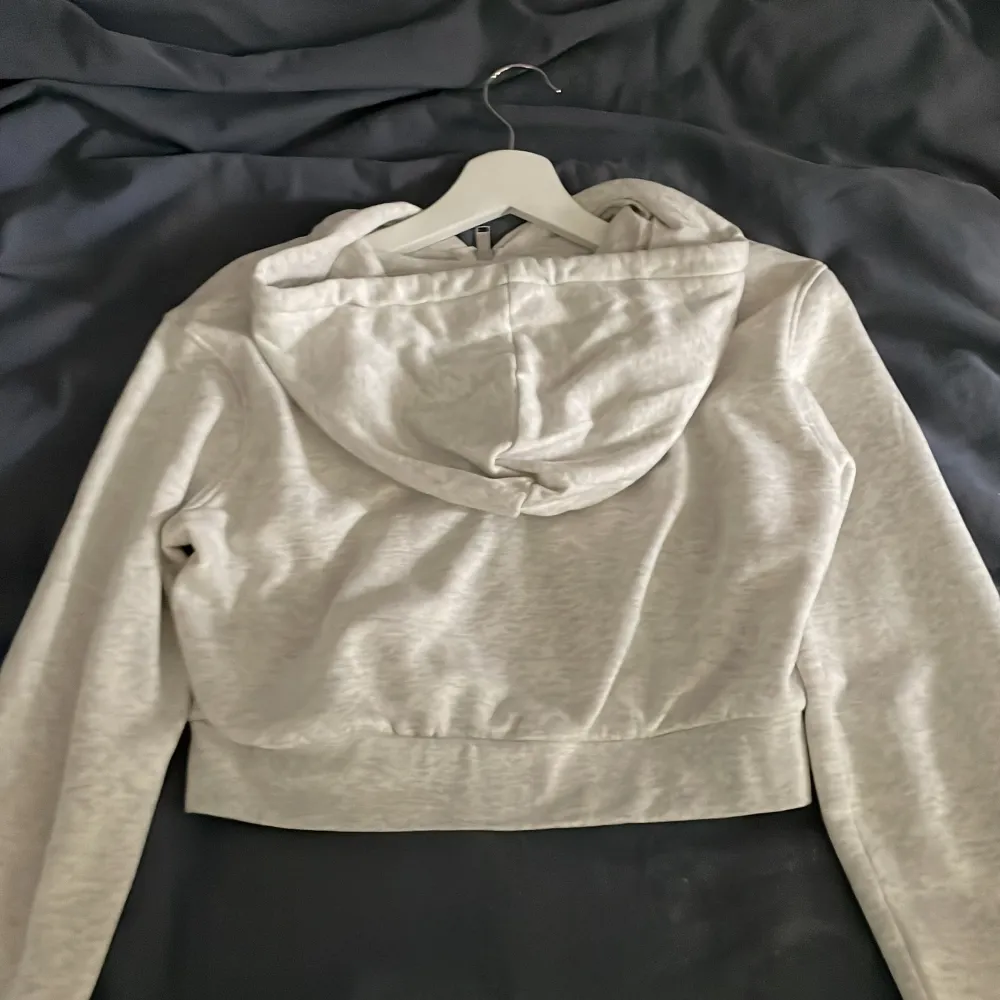 Säljer en kort grå zip hoodie från H&M. Använd 1-2 gånger så i toppen skick. Har fickor och snören. . Tröjor & Koftor.