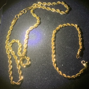 Cordell halsband/armband guldpläterad - Armbandet är 20cm långt och 3 mm brett samt gjort av rostfrittstål. Halsbandet är 50cm långt och 5 mm brett samt gjort utav rostfritt stål. Båda varorna är guldpläterade och i helt nyskick alltså inte använda alls.