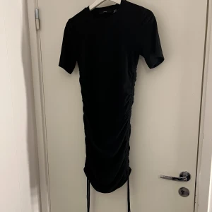 Klänning  - Klänning med knytning på sidorna. Storlek M