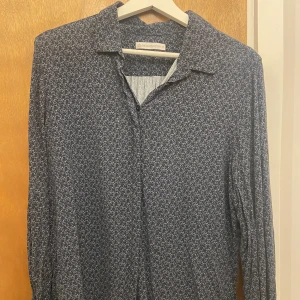 Blus  - Mönstrad blus med knyten på ärmarna från The shirt factory. 