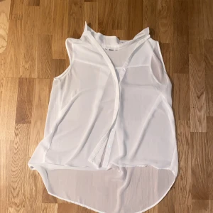 Vit blus  - En vit blus med silvriga knappar.