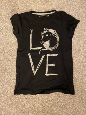 Svart rid t-shirt - Säljer denna t-shirten den är mycket använd men tvättad såklart. Jag säljer den för att jag har slutat i ridning och jag hade den som ridtröja. Jag fick den i julklapp så jag vet inte vad den kostar eller vad den kommer ifrån men jag säljer den för 10kr ❤️