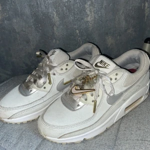 Nike Air Max 90   - Nike Air Max 90 White Gold. Fina skor med en nike kedja på som man kan ta av och ha för annat om man vill det! I storlek 38 och i bra skick trots att de är användna! 😁 