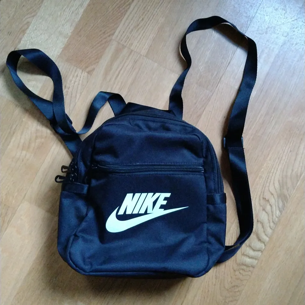 Nike mini backpack, helt ny och oanvänd! Höjd 25 cm, bredd 25 cm. Möts upp runt Bagarmossen, Stockholm eller köparen betalar frakten!✨. Väskor.