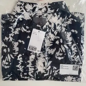 Säljer denna skjorta från H&M. Aldrig använd som ni ser på bilden då den är kvar i oöppnade påsen. Färgen är mörkblå med vitt mönster. Kontakta oss för fler frågor😁🙌🏼