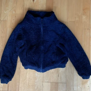 Fluffig zip-jacka - Säljer en mörkblå zip-jacka i fluffigt material. Den är i bra skick och trendig! Pris kan diskuteras, frakt tillkommer. 