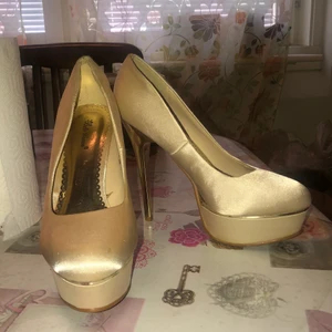 Champagnefärgade klackar - Köpta 2013. Använt en gång på studenten. Är i fina skick men har lite fläckar på sig som ni ser i bilden. Klackarna är höga och tyger är i ett silke material. Sulorna ser bra ut. Skorna är i storlek 38