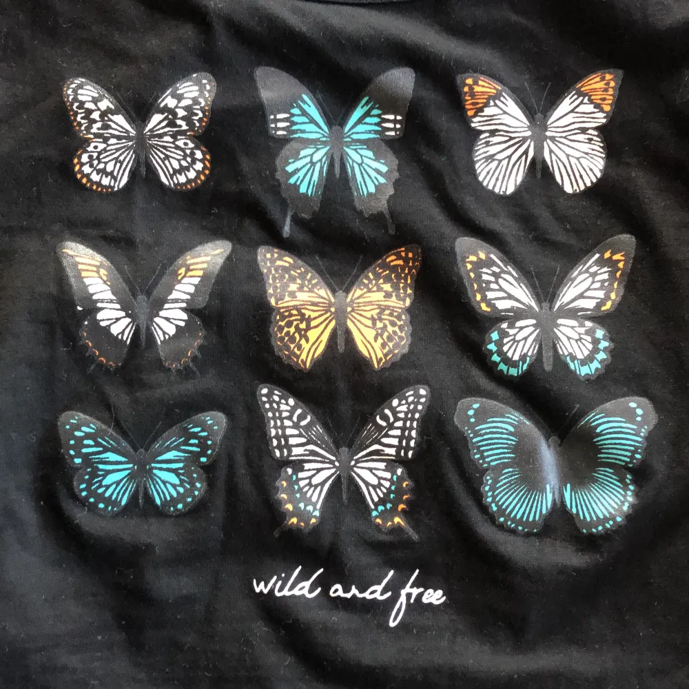 En kroppad svart T-shirt med fjärilar på från shein i strl S, använd typ 1 gång. 40 kr +frakt. Betalning via swish💜💜. Toppar.