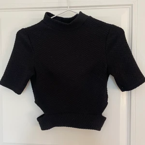 Topp med cutouts - Svart topp med polo pch cut outs på sidorna! Köparen står för frakt