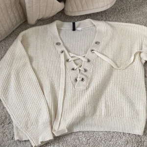 Stickad tröja med snörning storlek M - Stickad tröja med snörning i storlek M den Hm. Använd några gånger men har inga defekter 