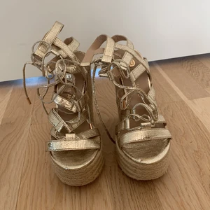 Kilklackar från River Island - Guldiga kilklackar från River Island. Knappt använda 