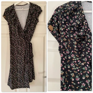 Klänning - Omlottklänning fr. Nelly. Strl. S.  Volanger framtill.  Tvättluddig på några ställen.  