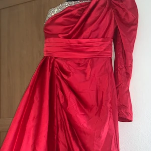 Balklänning/Bröllopsklänning  - Aldrig använt jättefin var bara inte för mig den är speciall beställd, passar till balen men också en klänning till ett bröllop, rödfärgad med en Axel och små diamanter vid bröstet, klänningen är lång för jag som är en och 173 så passar den perfekt, för mer information skriv(helt ny) pris går att snacka om 