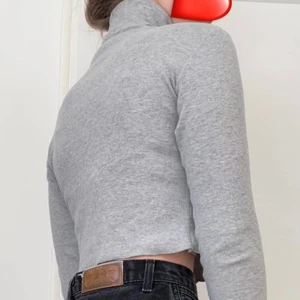 Grå ribbad långärmad polotröja - En perfekt basic croppad polotröja till hösten! perfekt till layering eller bara som den är! denna passar dig som är lite mindre. Säljer pga för kort i ärmarna (är 173cm lång och brukar ha storlek M)